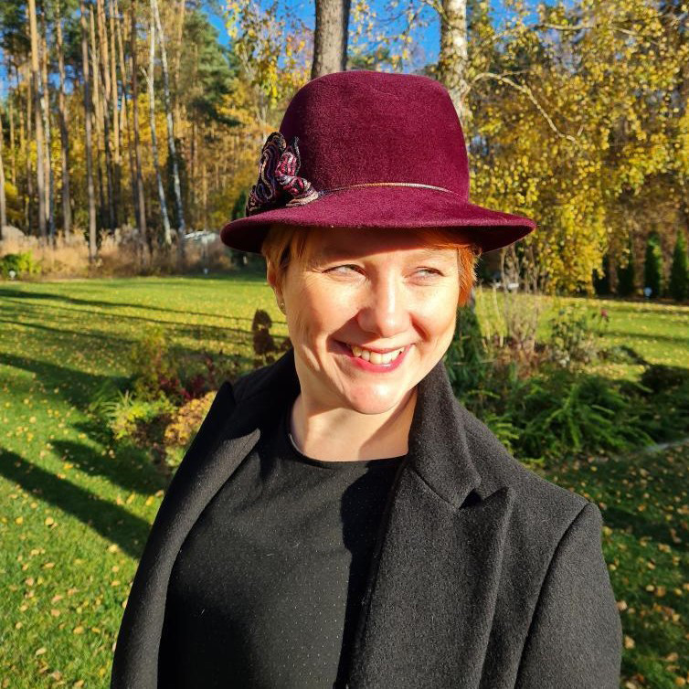 A sunny face with a big smile and a custom-made claret hat that complements the freckles and the red hair of its happy owner.