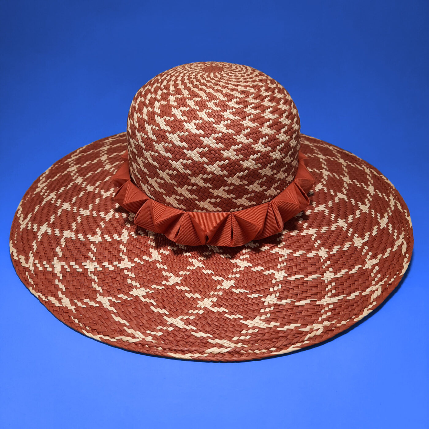 A large brim hat made of panama straw with a remarkable houndstooth pattern. This unique piece is elegant and casual at once.