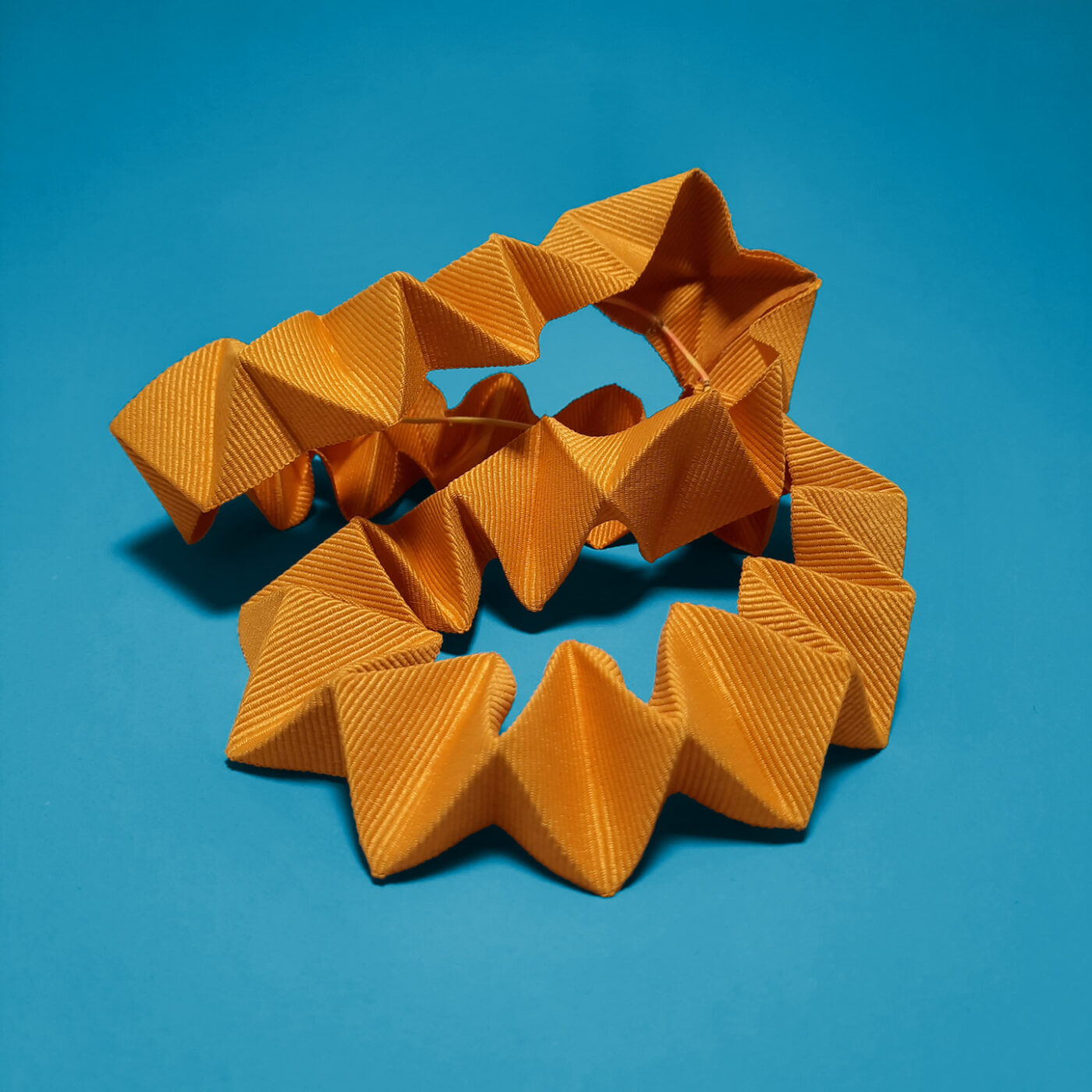 A yellow chameleon detail made of a pleated petersham ribbon. It can decorate a hat, be worn as a headband or a necklace.