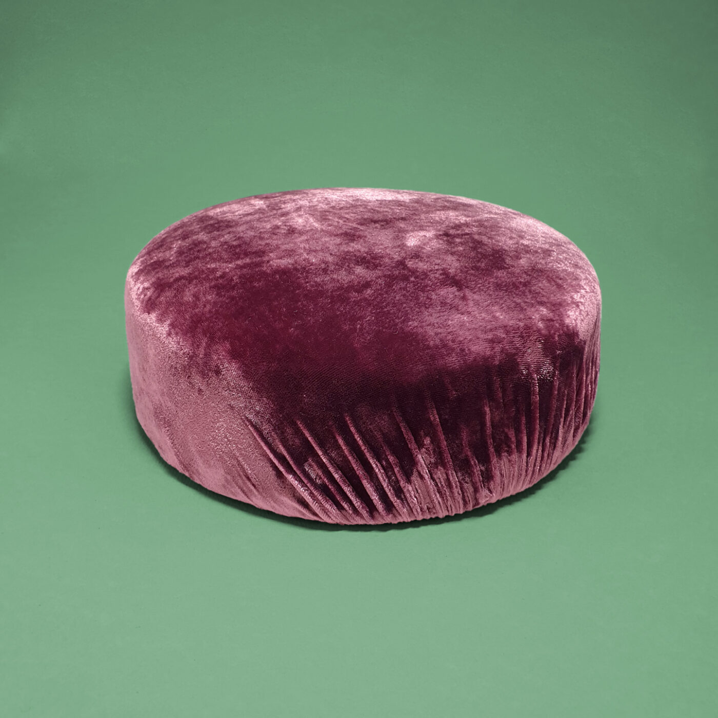 An exquisite pillbox hat made of aubergine velvet silk. The fabric's texture changes its aspect depending on the lighting.